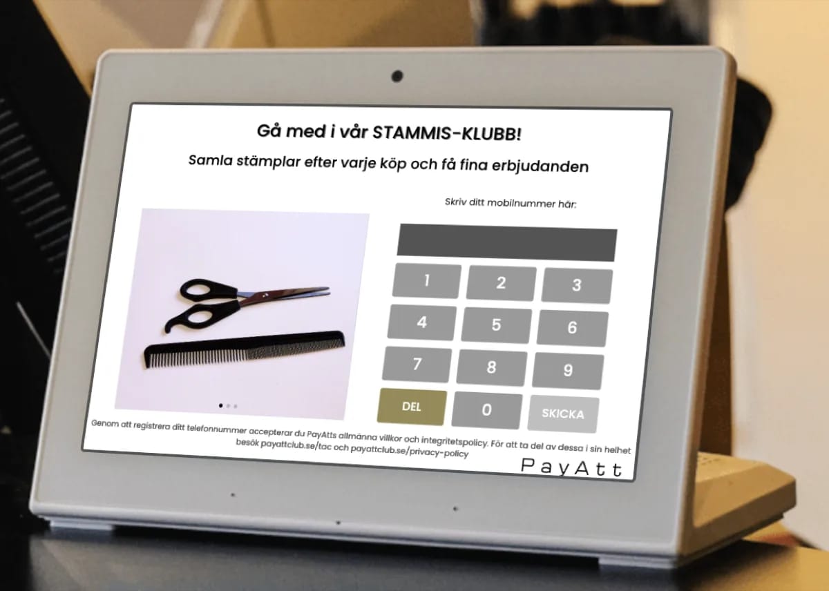 Registreringsskärm i en frisörsalong — kunden fyller i sitt mobilnummer